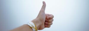 Close-up of a hand giving a thumbs up, signifying approval and recommendation of a service.