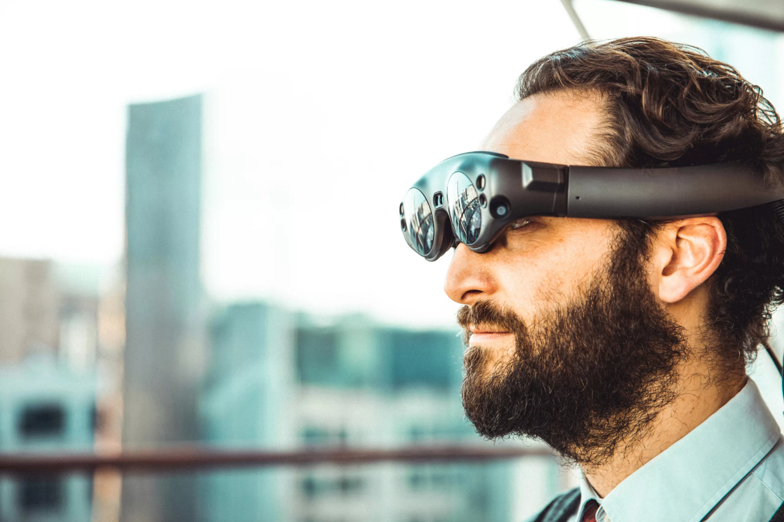 Man wearing augmented reality glasses with cityscape in the background